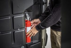 Person pulling truck safety accessories out of a work truck.